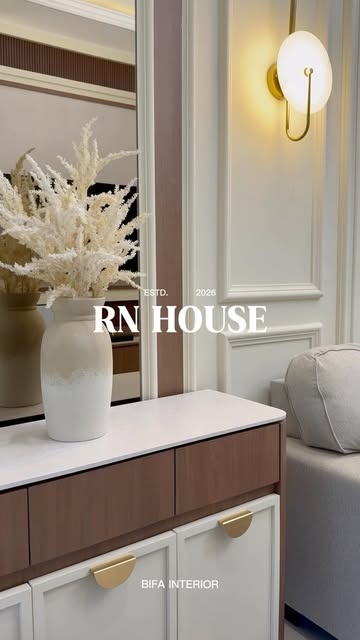 Interior RN House: kabinet konsol putih-walnut dengan handle emas dan lampu dinding